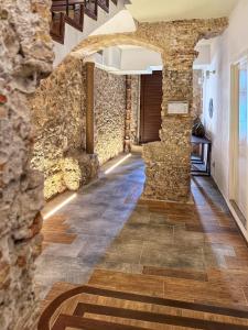 - un couloir dans un bâtiment doté de murs en pierre et de parquet dans l'établissement Casa Rosetta Boutique, à Xàtiva