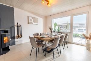 a dining room with a table and chairs and a fireplace at Eifel-Lodge Ferienhaus in Mendig