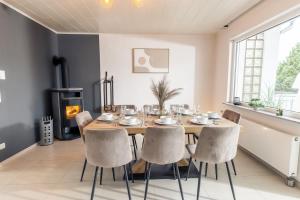 a dining room with a table and chairs and a fireplace at Eifel-Lodge Ferienhaus in Mendig