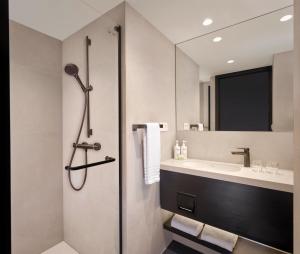a bathroom with a shower and a sink at Courtyard by Marriott Ghent in Ghent