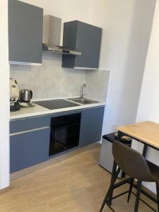a small kitchen with a sink and a table at Elegant R&B Floridia in Taormina