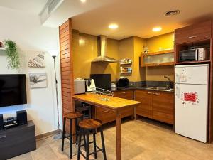 een keuken met een houten tafel en een koelkast bij El Loft de Salàs - L'Amfitriona in Salás de Pallás