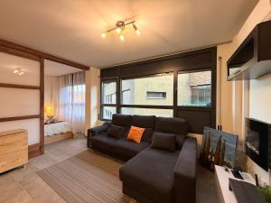 een woonkamer met een bank en een groot raam bij El Loft de Salàs - L'Amfitriona in Salás de Pallás