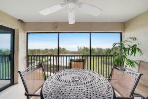 un tavolo e sedie su un balcone con una grande finestra di Sandpiper Beach #405 a Sanibel