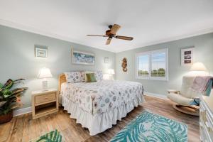 una camera da letto con un letto e un ventilatore a soffitto di Sandpiper Beach #405 a Sanibel