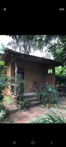 een klein huis met een bankje ervoor bij The Mud House in Talalla South