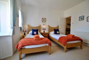 een slaapkamer met 2 bedden en oranje handdoeken bij Bayview - St Monans in Saint Monance