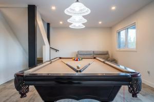 un tavolo da biliardo in un soggiorno con divano di Lake and Pool table - The Dorchester a Saint-Prosper