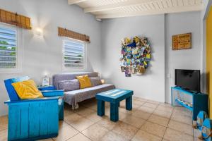 een woonkamer met een bank en een tv bij Barefoot Bonaire in Kralendijk