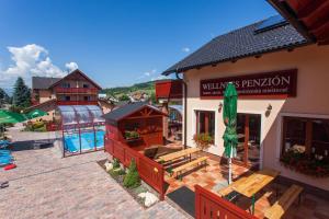 une vue aérienne sur un hôtel avec une piscine et un bâtiment dans l'établissement Penzion Motyl, à Bešeňová