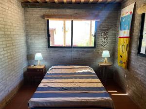 een slaapkamer met een bed en twee lampen op tafels bij Castillito de la viuda casa para 5o 6 personas in Punta Del Diablo