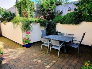een tafel en stoelen op een patio met planten bij The Stables in Prestatyn