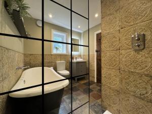 een badkamer met een bad, een toilet en een wastafel bij The Stables in Prestatyn