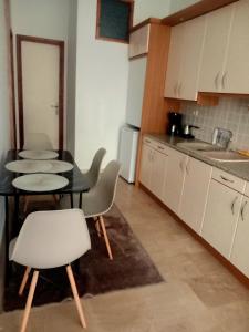 a kitchen with two tables and chairs and a kitchen counter at Guesthouse Aelia in Kato Loutraki