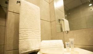 a bathroom with a sink and a mirror and towels at Signature Lodges in Islamabad