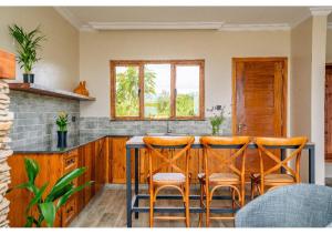 a kitchen with a bar with four stools at Inchorroi Cottages - champagne ridge in Oloyaingalani