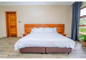 a bedroom with a large bed with a wooden headboard at Inchorroi Cottages - champagne ridge in Oloyaingalani