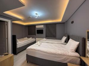 a bedroom with two beds and a tv on the ceiling at Atay Apart in Istanbul