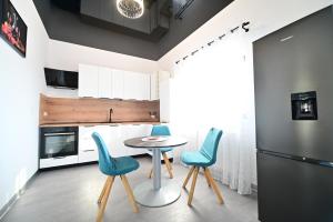 una cucina con tavolo e sedie blu di FLH - Vila Dominik a Sibiu