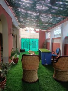 een kamer met groen tapijt en groene tafels en stoelen bij Red king home stay in Bikaner