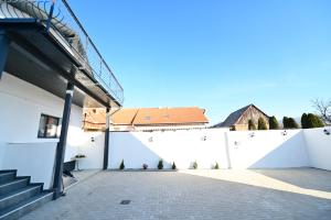 una recinzione bianca con una scala e un edificio di FLH - Vila Dominik a Sibiu