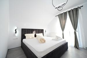 una camera da letto con un grande letto bianco con una finestra di FLH - Vila Dominik a Sibiu