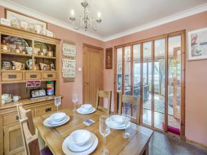 een eetkamer met een houten tafel en stoelen bij Lochside View in Lochearnhead