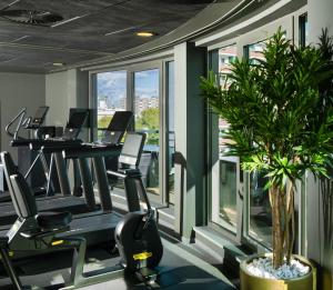 a gym with tread machines and a potted plant at SANA Berlin Hotel in Berlin +40 photos