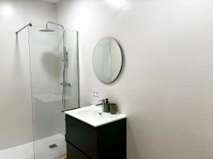 a bathroom with a sink and a shower with a mirror at TAYP Sol 120 in Seville +61 photos