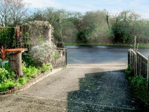 a garden with a gate and a fountain at Heath View Cottage in Westleton +6 photos