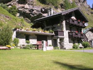 a stone house with a table in front of it at Chalet La Garde in Valtournenche