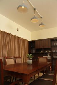 een eetkamer met een houten tafel en stoelen bij Luxurious Private Vantage Villa - Kotagiri in Kotagiri