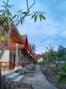 einen Gang, der zu einem Gebäude mit Bäumen führt in der Unterkunft Santhi Laba Bungalow in Nusa Penida