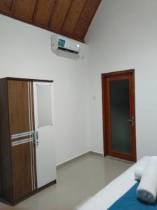 Zimmer mit einem Schrank und einer Tür in der Unterkunft Santhi Laba Bungalow in Nusa Penida + 5 Fotos
