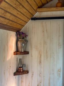 a vase on a shelf on a wall at Żuławska Zielona Przystań, całoroczny domek na kołach Sikorka in Izbiska