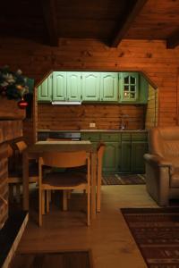 a kitchen with green cabinets and a table and chairs at Villa n'Mal in Orllan