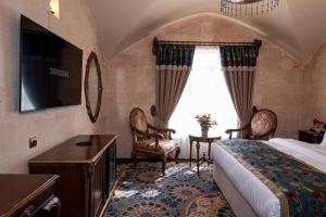 una camera da letto con un letto, una tv e una finestra di Maridin Hotel a Mardin