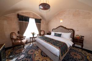 una camera da letto con un letto grande e due sedie di Maridin Hotel a Mardin Altre 51 foto