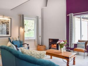 a living room with a couch and a table and a fireplace at Pilot Me Cottage in Staithes
