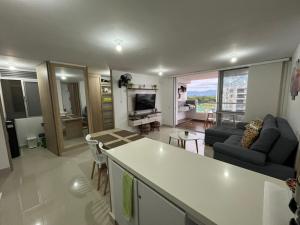 eine Küche und ein Wohnzimmer mit Sofa und Tisch in der Unterkunft Extraordinario Apartamento para Vacaciones en Ricaurte Cund in Ricaurte