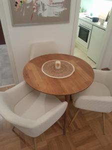 a wooden table in a kitchen with two white chairs at Appartment with Spa in Vienna