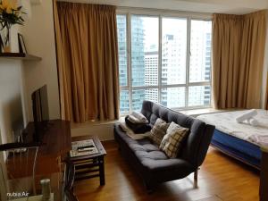 a living room with a couch and a large window at Parkview MALIKA KLCC in Kuala Lumpur