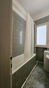 un bagno con vasca e finestra di The Perfect Location Studio! a Bucarest 1 altra foto