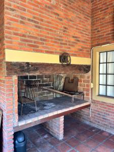 eine Ziegelmauer mit einer Bank und einem Stuhl in der Unterkunft Rincón del roble in Veinticinco de Mayo