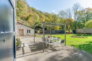a patio with a table and chairs in a yard at A Fleur de l'Eau Blanche gite de caractère in Chimay