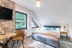 ein Schlafzimmer mit einem Bett, einem Fernseher und einem Tisch in der Unterkunft Apartamenty Sarnia 6A in Karpacz
