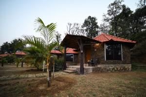 a house with a palm tree in front of it at Adventure Inn Dandeli 2 in Dandeli +9 photos