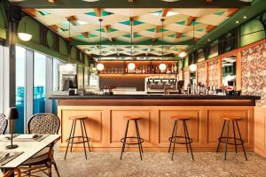 a restaurant with a bar with stools in front at Zeus Essence Athens Central, former Athens Key in Athens