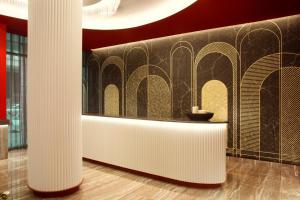 eine Lobby mit Säulen und einer Wand mit einem Tisch in der Unterkunft Zeus Essence Athens Central, former Athens Key in Athen