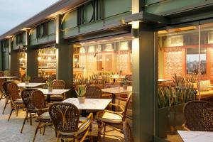 ein Restaurant mit Tischen, Stühlen und Fenstern in der Unterkunft Zeus Essence Athens Central, former Athens Key in Athen + 37 Fotos